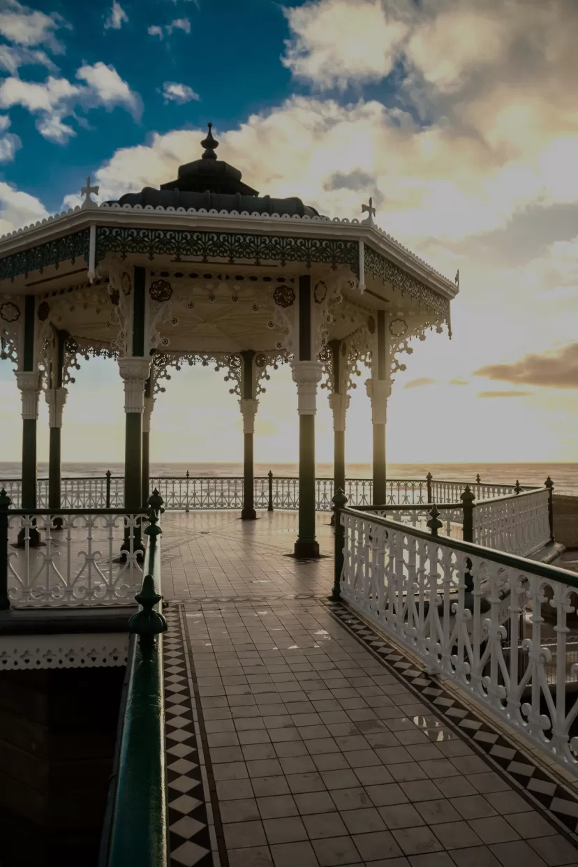 A striking photo of the bandstand on the seafront in Brighton. The structure has been totally renovated and the detailed iron work is silhouetted against the sky.