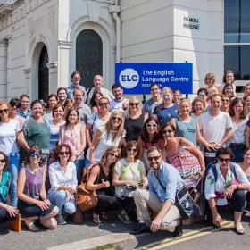 A group shot of many English language teachers from around the world who have gathered for this photo in front of the ELC Brighton school building. It's a sunny day and all these teachers will have just completed a two-week English teachers' course. This photo was taken back in 2018, but it's a great photo showing lots of happy faces.