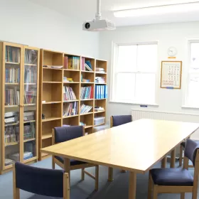 The resource centre in Chester this is where teachers can access the materials they need to prepare lessons and there's a long rectangular table with chairs for them to sit and discuss the English lessons they are going to give