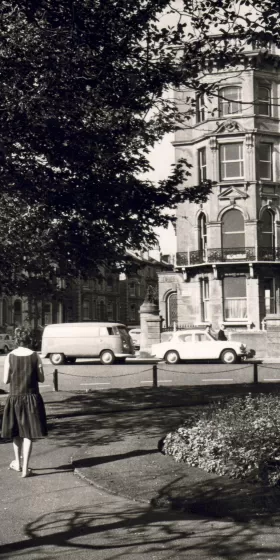 An old photo of the English Language Centre in Brighton. You can see some old cars and a van in the photo, which is black and white.