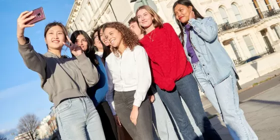 A group of students pose as one of the group takes a selfie. For now they're just outside the ELC Brighton building but it looks like they might be off on a walking tour of Brighton.