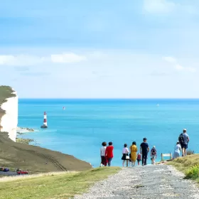 An almost unreal looking photo of students walking down the path towards the natural feature of Birling Gap. In the background you can see the white chalky cliffs of the coastline rising up and the Beachy Head lighthouse can be seen. This area is a very short drive from Eastbourne where ELC's English school is located.
